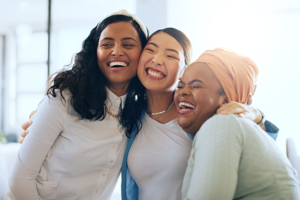 three young woman all laughing together