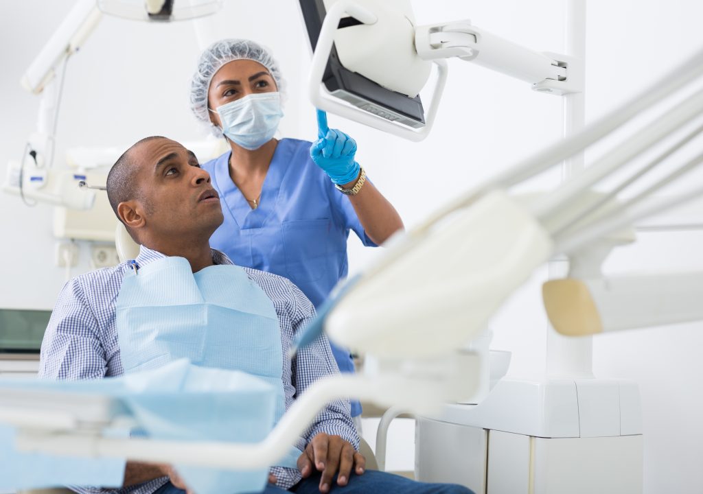 patient looking at his dental x-rays at the dentist's office