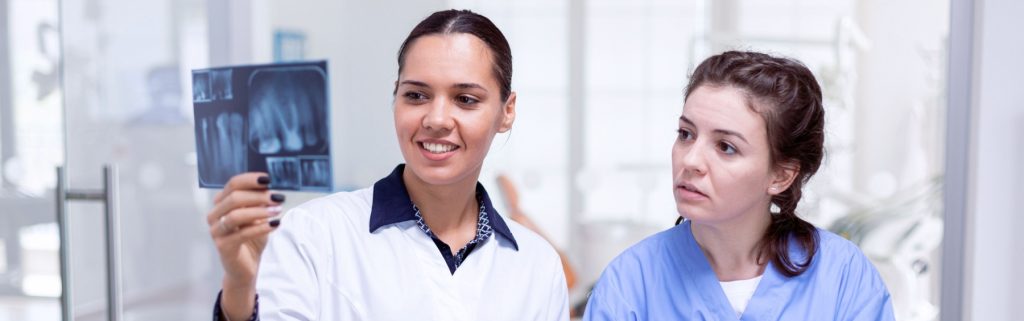 Dentists and patients looking at dental x-rays